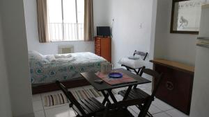 a room with a table and chairs and a bed at Kitinet na Praia de Botafogo in Rio de Janeiro