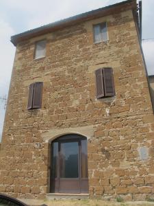 un edificio in mattoni con tre finestre e una porta di Mozzafiato Pitigliano a Pitigliano