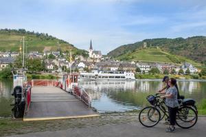 two people on bikes on a dock near a body of water at Gasthaus Rosenberg in Klotten