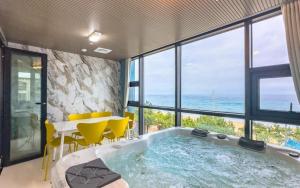 bañera en una habitación con mesa y sillas en 안목을높이다 펜션, en Kyŏnso