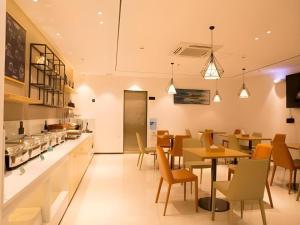 a restaurant with a dining room with tables and chairs at City Comfort Inn Zhuhai Doumen Daxin Xinduhui Pedestrian Street in Towmoon