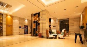 长沙City Comfort Inn Changsha Outlets Datuo Metro Station的大楼内设有桌椅的大厅