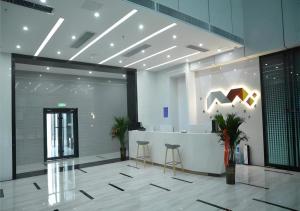 济南Borrman Hotel Ji'nan Aoti Center East Provincial Hospital的大楼内带柜台和凳子的大堂