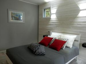 una camera da letto con un letto con cuscini rossi e bianchi di La Désirade a Saint-Laurent-de-la-Prée