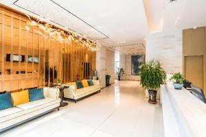 拉萨City Comfort Inn Lhasa Potala Palace Scenic View的宽敞的大堂，配有沙发和植物