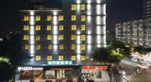 un palazzo alto con luci accese di notte di City Comfort Inn Qingyuan Longtang Light Rail Changlong a Yinzhan'ao
