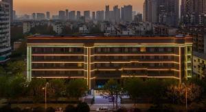 a lit up building in front of a city at City Comfort Inn Hefei 1912 Ganghui Plaza in Hefei