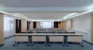 a large room with rows of tables and chairs at City Comfort Inn Hefei 1912 Ganghui Plaza in Hefei