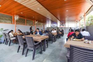 VagholiにあるVia Yashraj Inn - BJS Collegeのレストランのテーブルに座っている人々のグループ