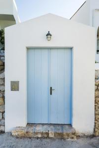 Villa Giasemi في سبيتسيس: باب الكراج الأزرق على مبنى أبيض +20 صورة