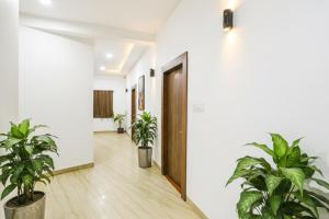 an empty hallway with potted plants and a door at FabHotel Duke Inn in Bhopal