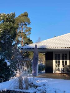 Un paraguas azul frente a una casa en la nieve en Perfect Base Near Beach And Shops, en Bøtø By