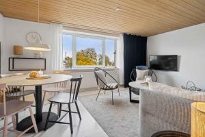 una sala de estar con una mesa y sillas en Beautifull 2-Room Apartment With Sea View, en Sandvig