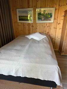 1 cama en una habitación con 2 cuadros en la pared en Perfect Base Near Beach And Shops, en Bøtø By