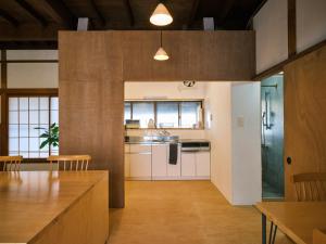 a kitchen with white cabinets and a wooden floor at 湊庵錆御納戸-so-an sabionand- in Higashiizu