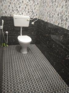a bathroom with a toilet in a black and white bathroom at Gokarna 2Bhk,Kitchen,AC and Non AC Stay in Gokarna
