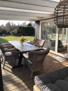 a wooden deck with a wooden table and chairs at Lovely Holiday Home With Annex And Garden in Dronningmølle