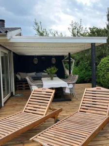 two chairs and a table on a wooden deck at Lovely Holiday Home With Annex And Garden in Dronningmølle