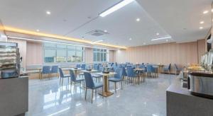 un ristorante con sedie e tavoli e sedie blu di Green Tree Inn Zhejiang Ningbo Yuyao Haijixincheng Wholesales Market a Yuyao