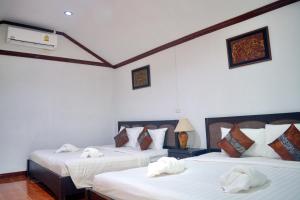 a bedroom with two beds with white sheets at Lanta IL Mare Beach Resort in Ko Lanta