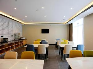 a dining room with tables and chairs and a tv at GreenTree Inn Express Jinan Zhangqiu Districty Ancinet Town Longquan Road in Zhangqiu +42 photos