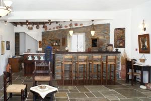 a room with a bar and some tables and chairs at Fassolou in Faros