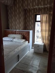 a bedroom with a large bed with a window at Aparta Homestay in Pekayon Satu