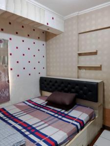 a bedroom with a bed with a wall with red dots at Aparta Homestay in Pekayon Satu