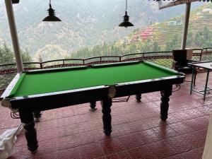 a green pool table in a room with a view at Dhanolti Apple Orchard Resort in Dhanaulti
