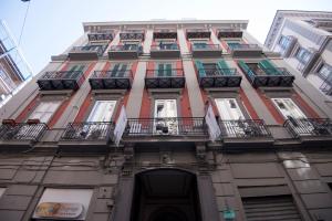 a tall building with balconies and flags on it at Schilizzi Hotel in Naples