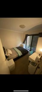 悉尼Hidden Gem North Sydney的卧室里有一张床和一张带灯的桌子