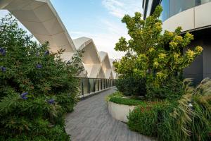 een wandelpad met planten en bloemen op een gebouw bij Apartments Akash - Tashkent City Residence in Tasjkent