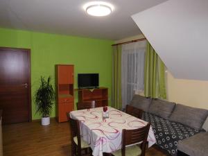 a living room with a table and a couch at Apartment U Sedláčků in Benecko