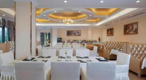 a large dining room with white tables and white chairs at Vienna Hotel Chongqing Yongchuan High-Speed Railway Station Xinglong Lake in Yongchuan