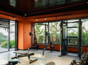 een fitnessruimte met 2 loopbanden in een kamer met ramen bij Apartments Akash - Tashkent City Residence in Tasjkent