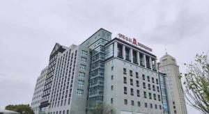 a tall white building with a sign on top of it at Jinjiang Inn Jiaxing South Lake in Jiaxing