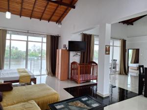 Una sala de estar con un sofá y un televisor en Amber House Lanka, en Bentota