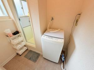 Waschmaschine und Trockner in einer Ecke eines Zimmers in der Unterkunft ハイツ緑ヶ丘103 in Nagasaki