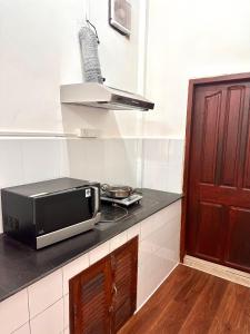 een magnetron op een aanrecht in een keuken bij Vientiane Semi detached house in Vientiane
