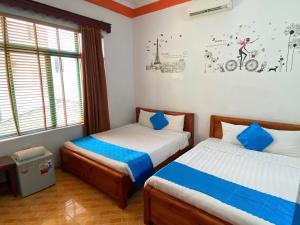a bedroom with two beds and a window at Alex Hostel in Ha Long