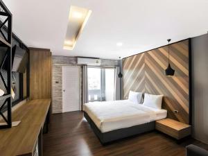 a bedroom with a bed and a wooden wall at The Circle Hotel in Ban Bu Lamduan +92 photos