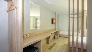 a bedroom with a desk and a bed with a mirror at B2 Buriram Boutique and Budget Hotel in Ban Khok Wat +109 photos