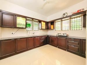 钦奈Royal Holiday Homes 4BHK premium Luxury Beach Villa, Uthandi的一个带木制橱柜和窗户的大厨房