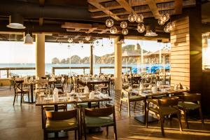 Casa Dorada Los Cabos Resort & Spa في كابو سان لوكاس: مطعم به طاولات وكراسي ومطل على المحيط