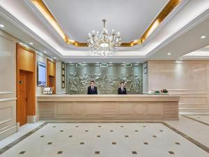 西安Vienna Hotel Xi'an Zhonglou的两名男子站在大堂的前台