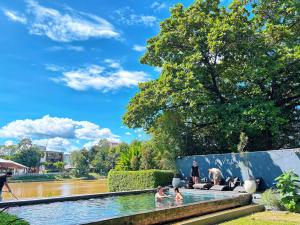 a pool in a park with people in the water at i-river chiangmai in Chiang Mai