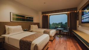 a hotel room with two beds and a large window at Coral Reef Kakkanad in Cochin +36 photos