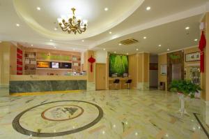 a lobby with a clock on the floor of a building at Vatica Hangzhou Linan Qianwang Street Hotel in Lin'an