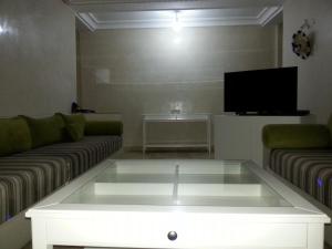 un soggiorno con divano e TV di Apartment Residence Rivaldi Achakar a Mediouna