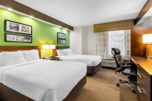 ein Hotelzimmer mit zwei Betten und einem Schreibtisch und einem Stuhl in der Unterkunft Sleep Inn Beaver- Beckley in Beaver + 62 Fotos